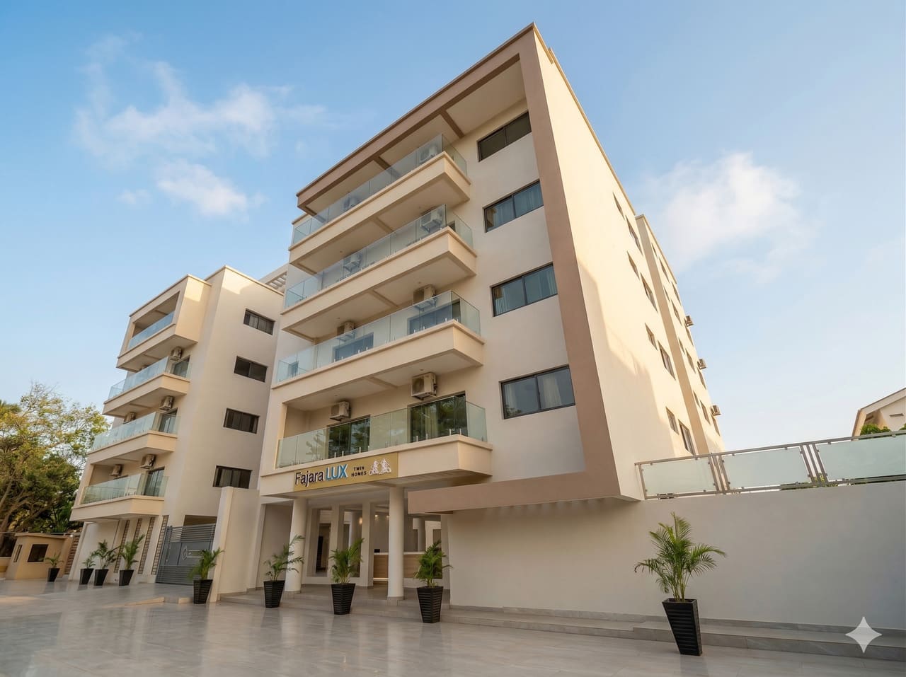 Corner view of Fajara Lux showing four storeys of recessed balconies and the entrance signage