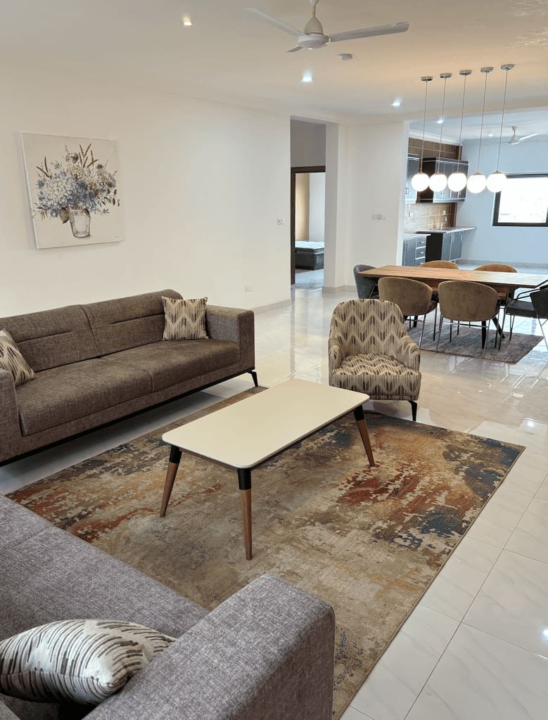Living room in a Fajara Lux apartment looking through to the dining area and fitted kitchen beyond